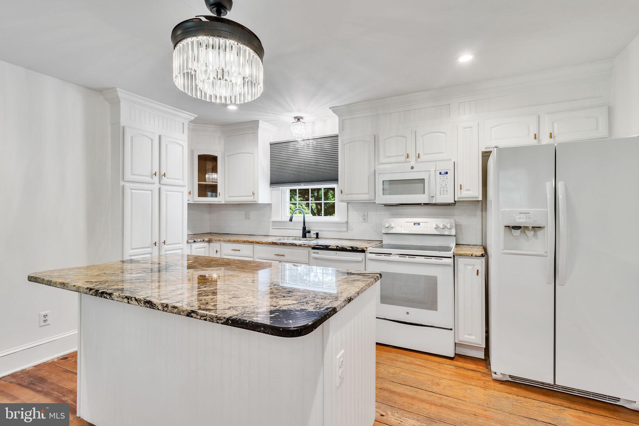 3952 Irvington Road Irvington, VA 22480 - Photo 15 of 77 a kitchen with kitchen island granite countertop stainless steel appliances a sink stove and refrigerator