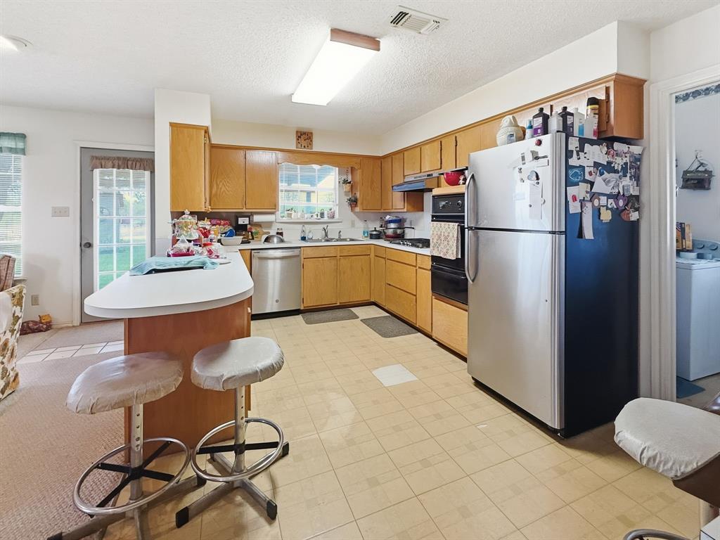 2315 County Road 208 Hico, TX 76457 - Photo 13 of 39 a kitchen with a refrigerator a stove a dining table and chairs