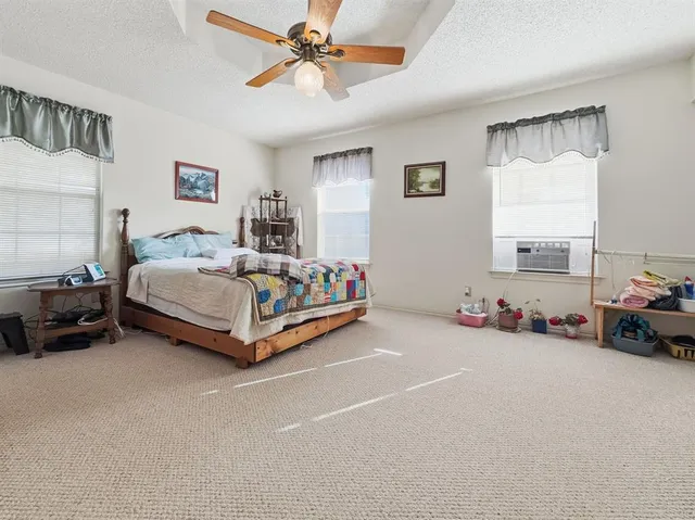 a spacious bedroom with a bed and a chandelier