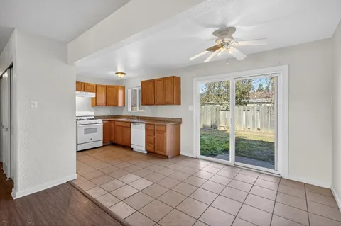 a view of kitchen with granite countertop cabinets and window