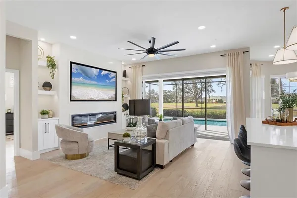 a living room with furniture ceiling fan and a large window