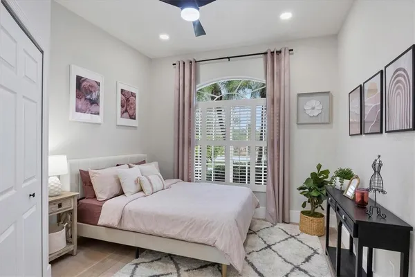 a bedroom with a large bed and a potted plant