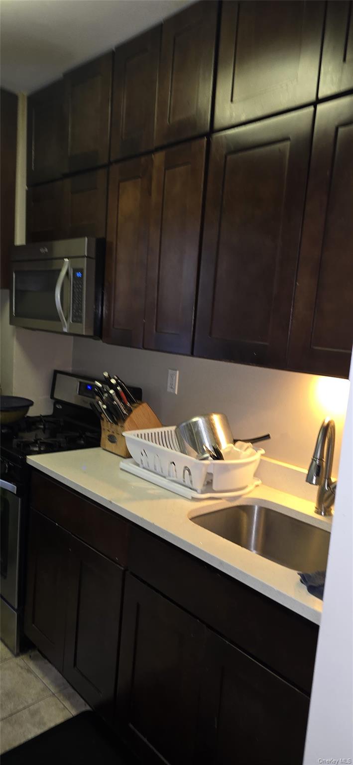 104-23 118th Street Queens, NY 11419 - Photo 2 of 3 a kitchen with a sink a stove and cabinets