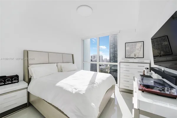 a bedroom with a bed and a flat screen tv