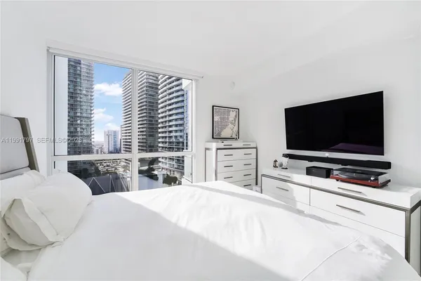 a bedroom with a bed and a flat screen tv
