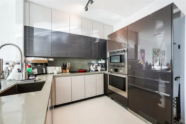 a kitchen with stainless steel appliances kitchen island granite countertop a stove refrigerator and sink