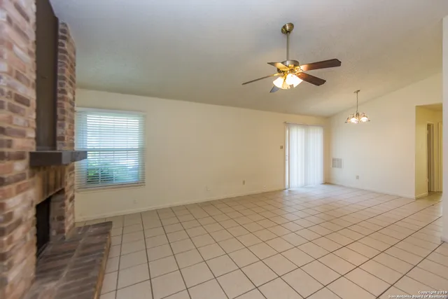 a view of empty room with window and ceiling fan