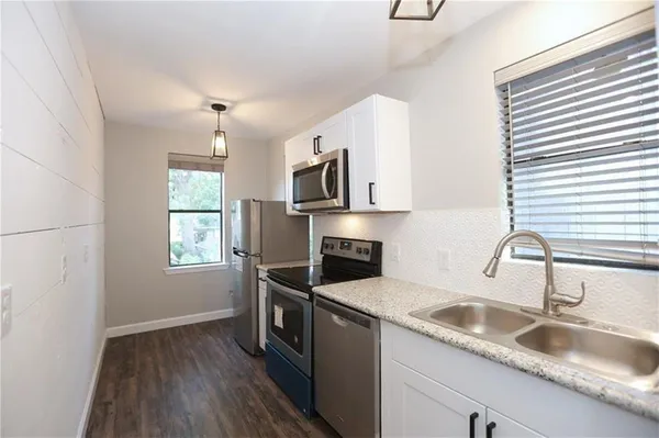 a kitchen that has a sink and a stove top oven