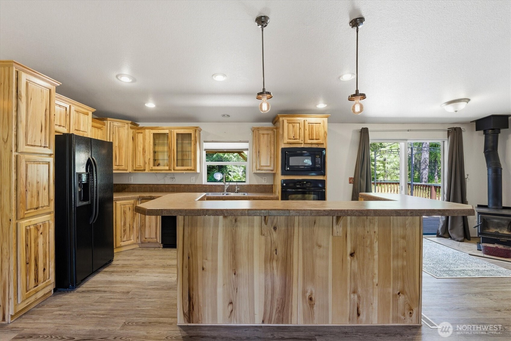 1142 Driskill Road Newport, WA 99156 - Photo 11 of 40 a kitchen with stainless steel appliances granite countertop a refrigerator a sink dishwasher a oven and a dining table with wooden floor