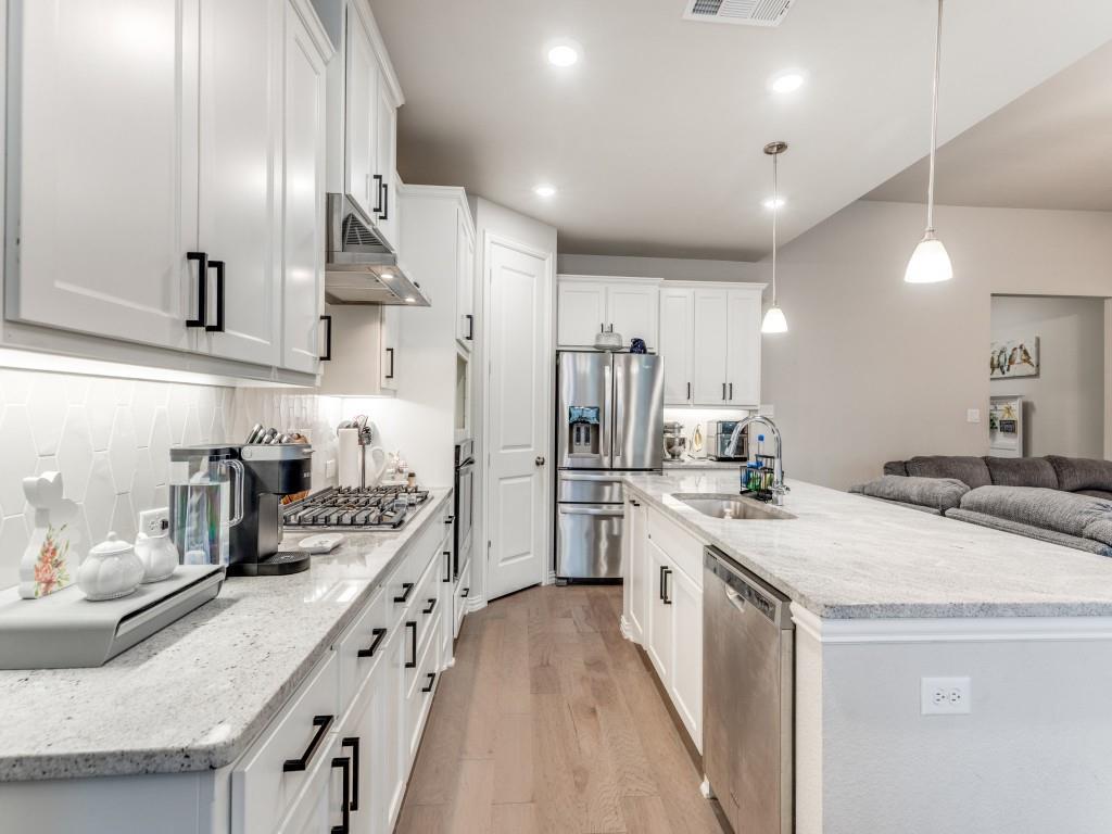 1608 Carnation Street Prosper, TX 75078 - Photo 12 of 25 a kitchen with stainless steel appliances a sink and stove