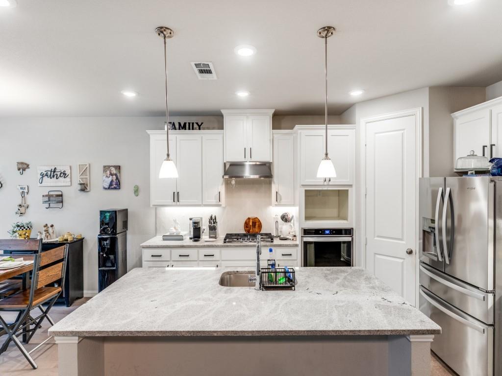 1608 Carnation Street Prosper, TX 75078 - Photo 13 of 25 a kitchen with stainless steel appliances granite countertop a sink refrigerator and cabinets