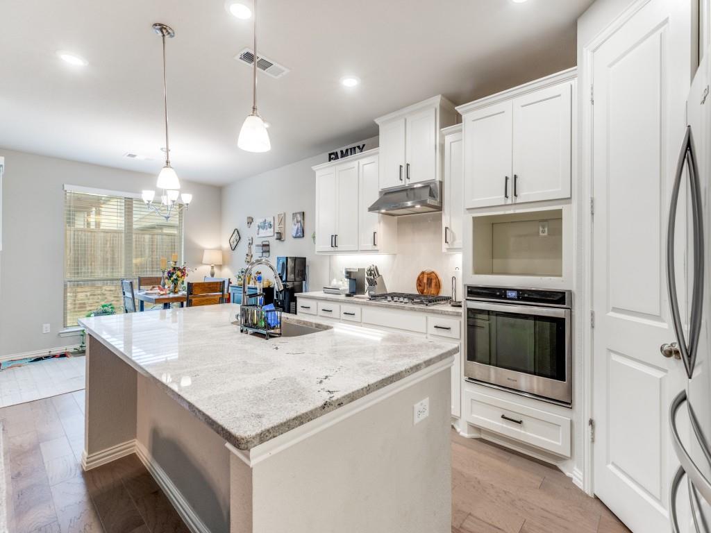 1608 Carnation Street Prosper, TX 75078 - Photo 14 of 25 a kitchen with stainless steel appliances granite countertop a sink a stove and a refrigerator