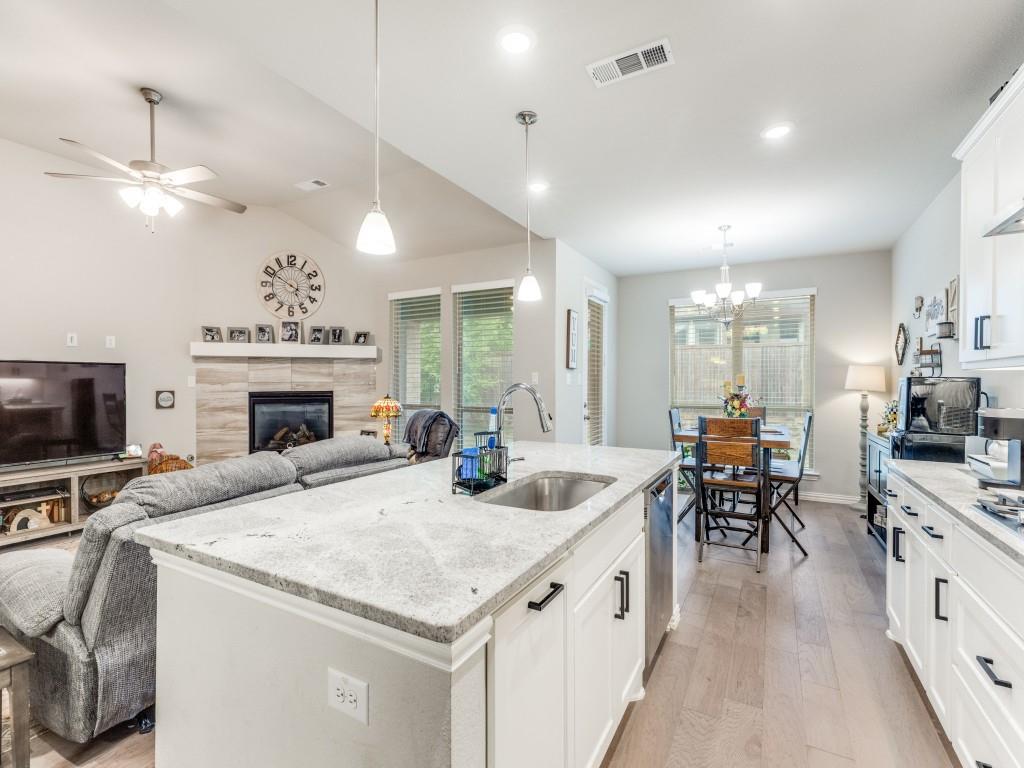 1608 Carnation Street Prosper, TX 75078 - Photo 15 of 25 a large kitchen with sink a refrigerator and chairs