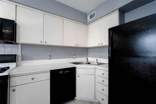 a kitchen with a sink dishwasher and cabinets