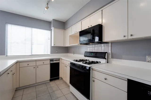 a kitchen with cabinets appliances a sink and a window