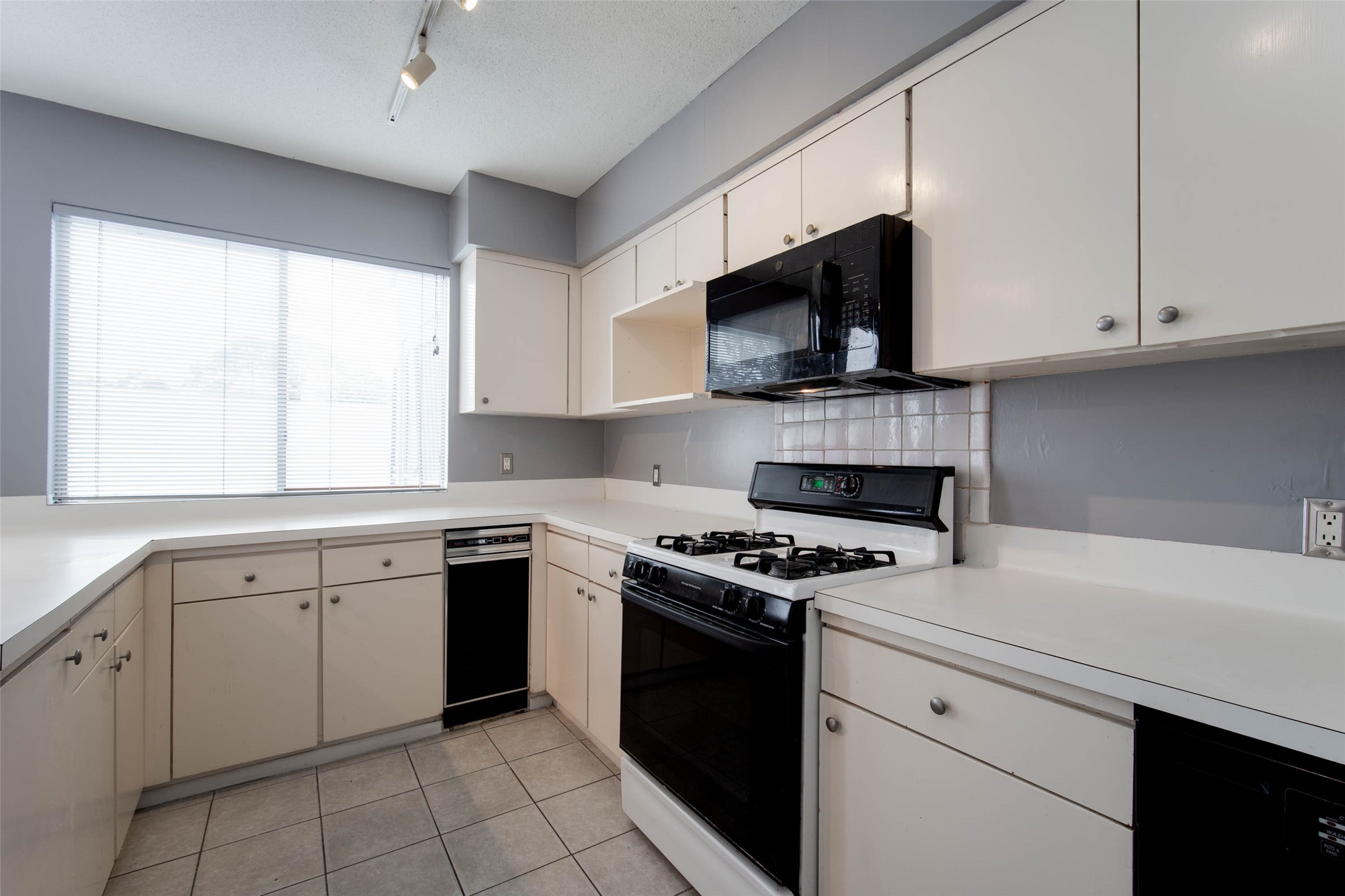 6311 Riverview Way Houston, TX 77057 - Photo 20 of 35 a kitchen with cabinets appliances a sink and a window