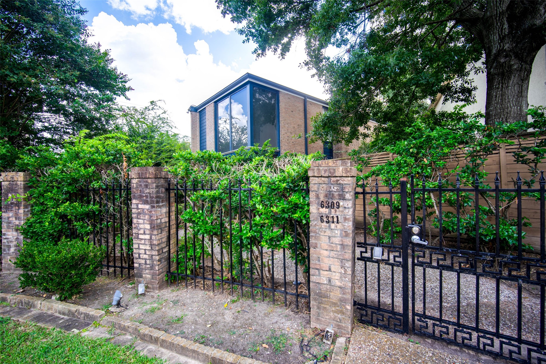 6311 Riverview Way Houston, TX 77057 - Photo 2 of 35 a view of a brick house with a small yard and plants