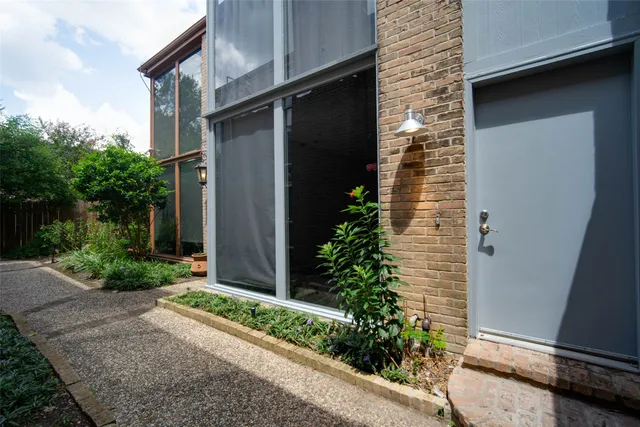 a brick house with a yard and plants
