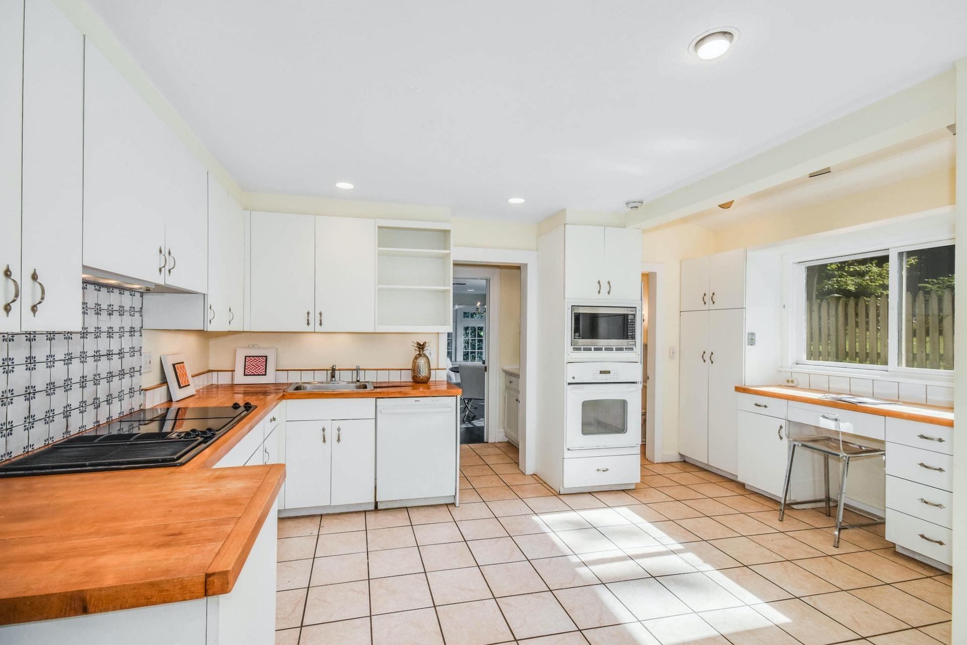 221 Mill Road New Canaan, CT 06840 - Photo 11 of 32 a kitchen with granite countertop a refrigerator and a stove top oven