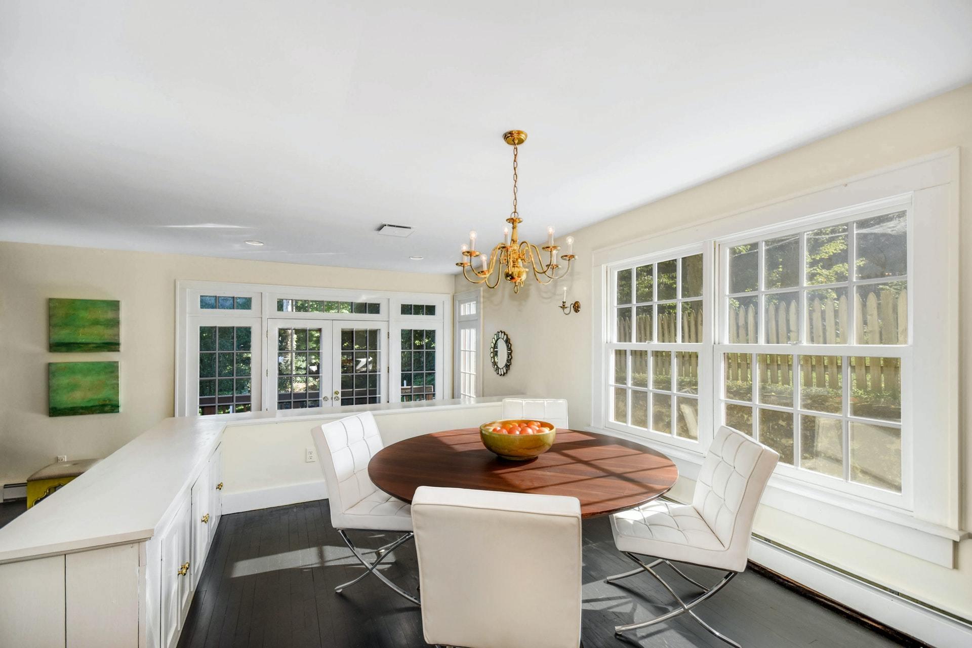 221 Mill Road New Canaan, CT 06840 - Photo 19 of 32 a view of a dining room with furniture large windows and wooden floor