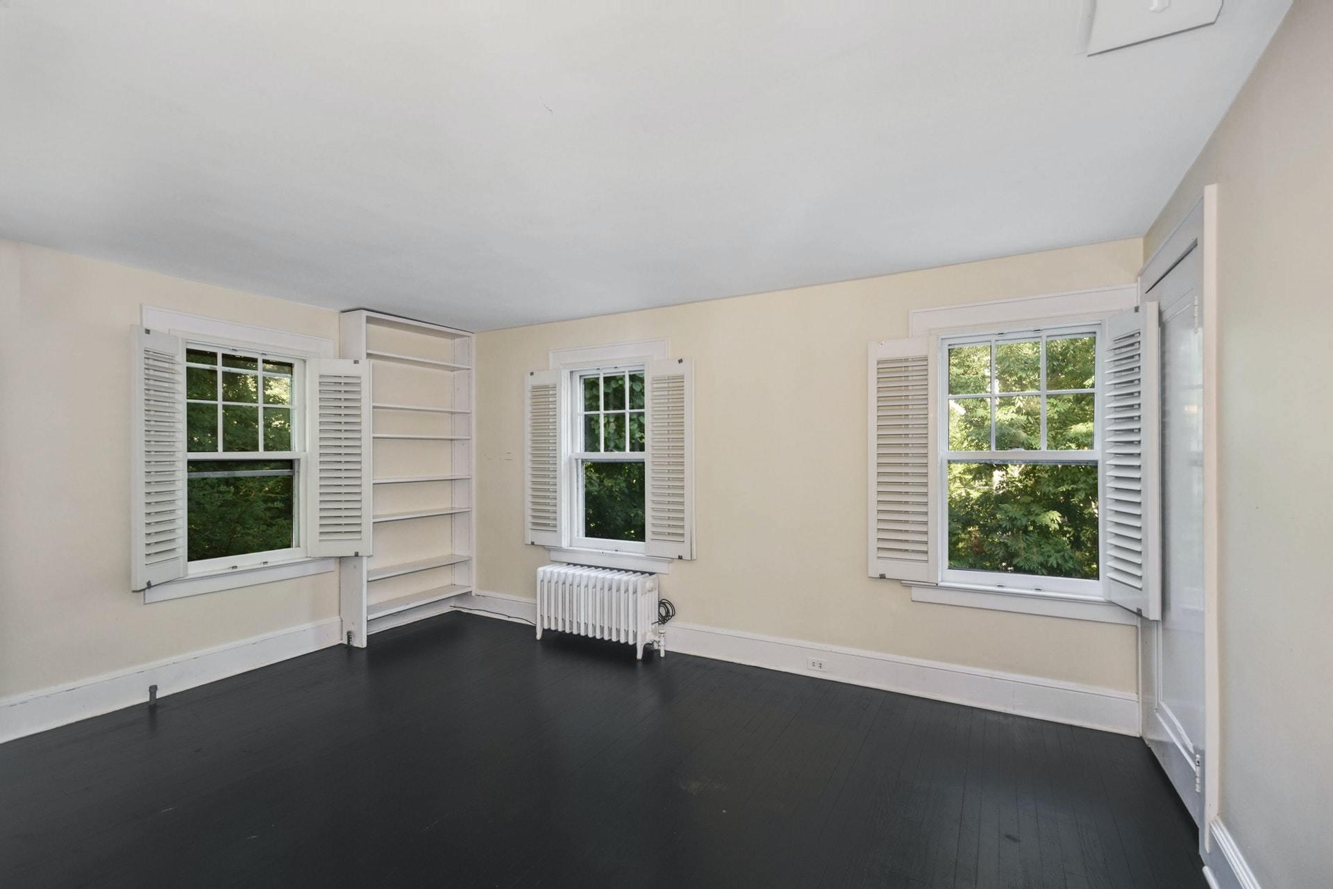 221 Mill Road New Canaan, CT 06840 - Photo 25 of 32 a view of an empty room with wooden floor and a window