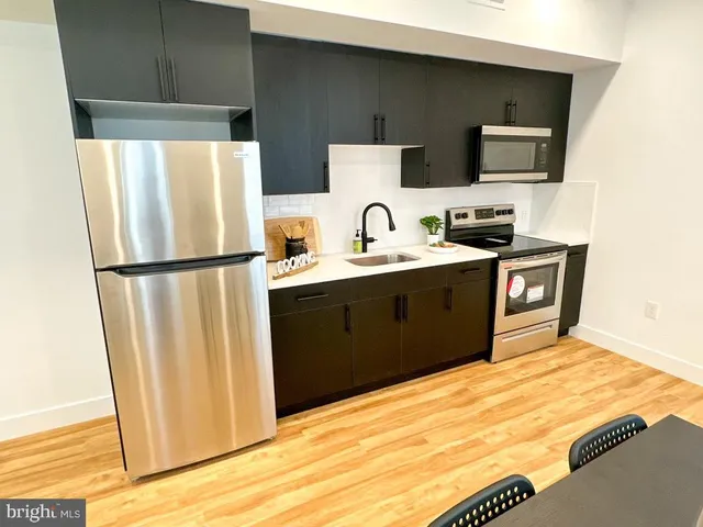 a kitchen with stainless steel appliances granite countertop a refrigerator a stove a sink and a microwave