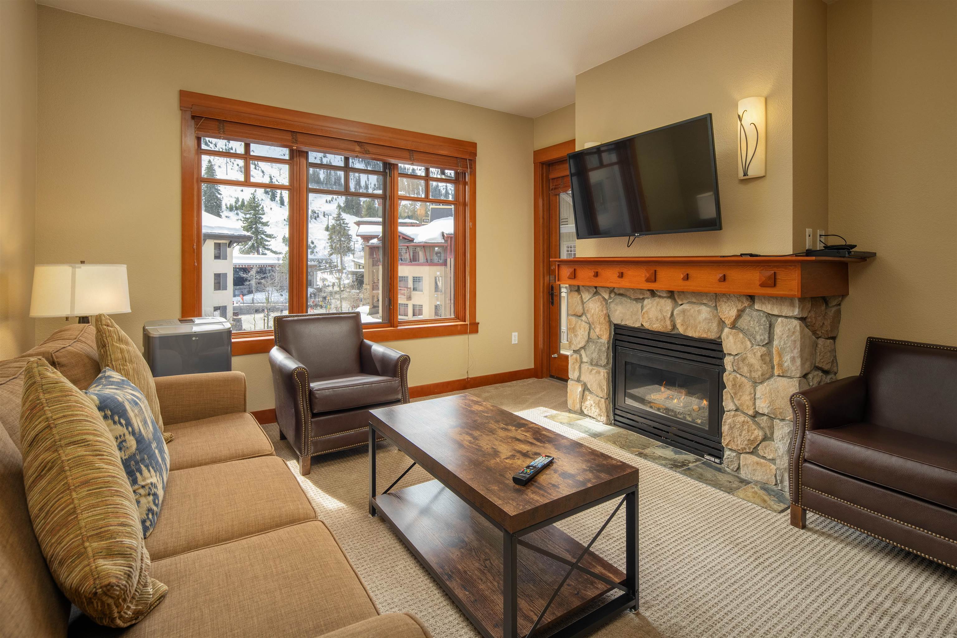 1985 Olympic Vly Road, Unit 2424 Olympic Valley, CA 96146 - Photo 4 of 21 a living room with furniture a flat screen tv and a fireplace