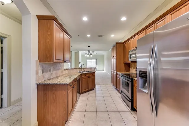 a kitchen with granite countertop stainless steel appliances and wooden cabinets