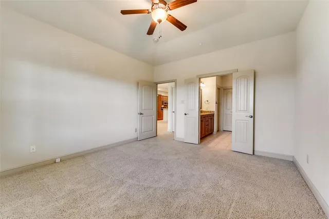 an empty room with closet and a ceiling fan