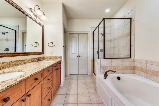a bathroom with a granite countertop tub sink shower and mirror