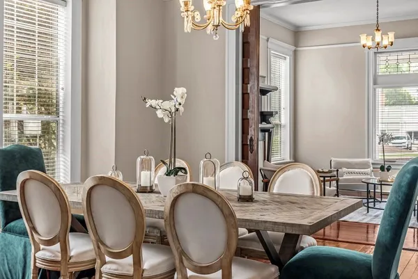a kitchen with stainless steel appliances granite countertop a dining table chairs refrigerator and microwave