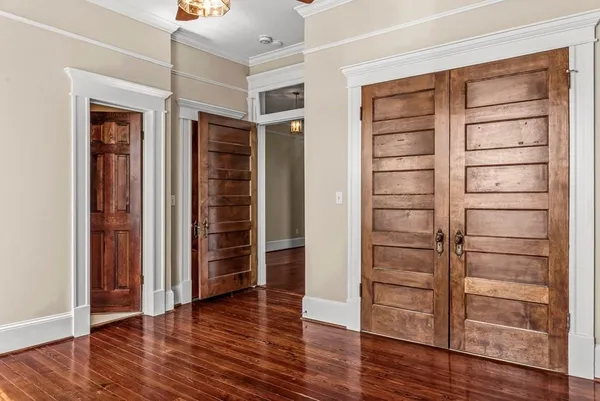 a view of a hallway with wooden floor and windows