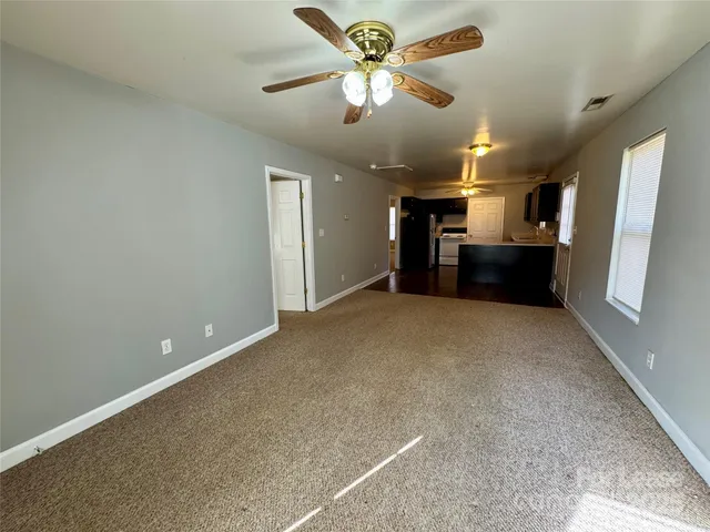 en empty room with windows and fan