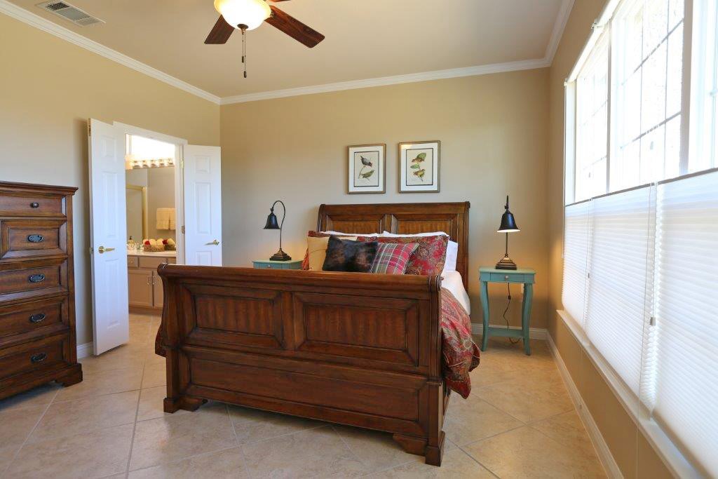 109 Ranier Lane Georgetown, TX 78633 - Photo 10 of 18 Well-lit sleeping quarters with a richly carved bed frame and convenient bathroom access.
