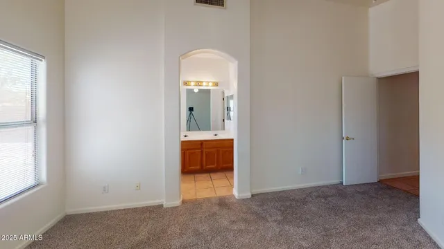 an empty room with windows and bathroom view