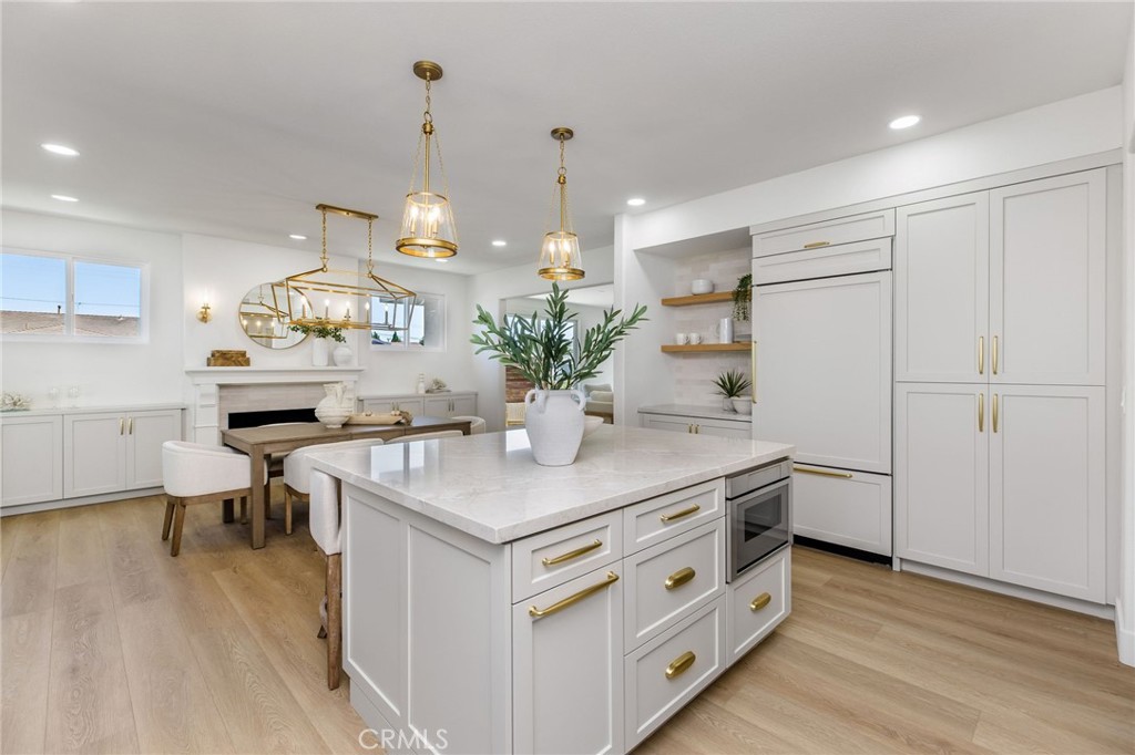 245 Surf Place Seal Beach, CA 90740 - Photo 22 of 65 a kitchen with a sink dishwasher a dining table and chairs with wooden floor