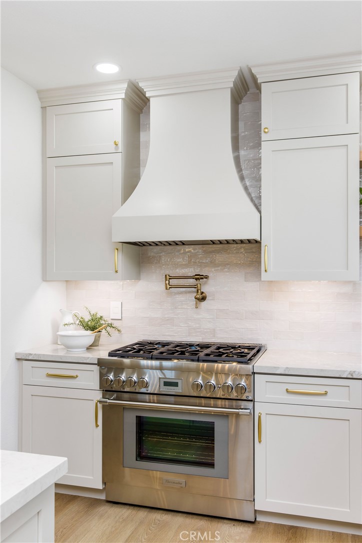 245 Surf Place Seal Beach, CA 90740 - Photo 26 of 65 a kitchen with a stove and a white cabinet
