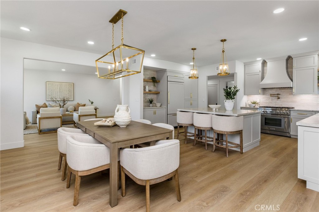 245 Surf Place Seal Beach, CA 90740 - Photo 27 of 65 a dining room with wooden floor a chandelier a wooden table and chairs