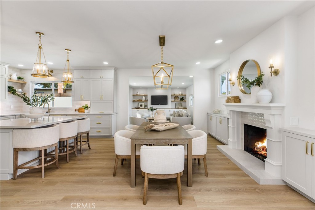 245 Surf Place Seal Beach, CA 90740 - Photo 28 of 65 a dining room with furniture a fireplace and a chandelier