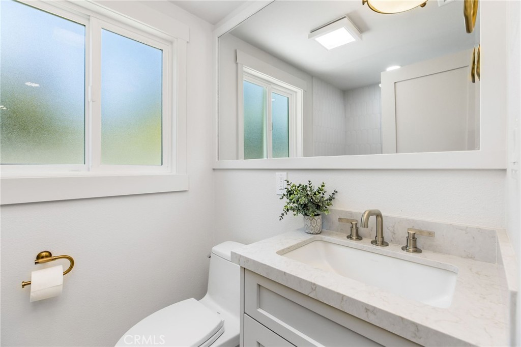 245 Surf Place Seal Beach, CA 90740 - Photo 38 of 65 a bathroom with a toilet sink and mirror