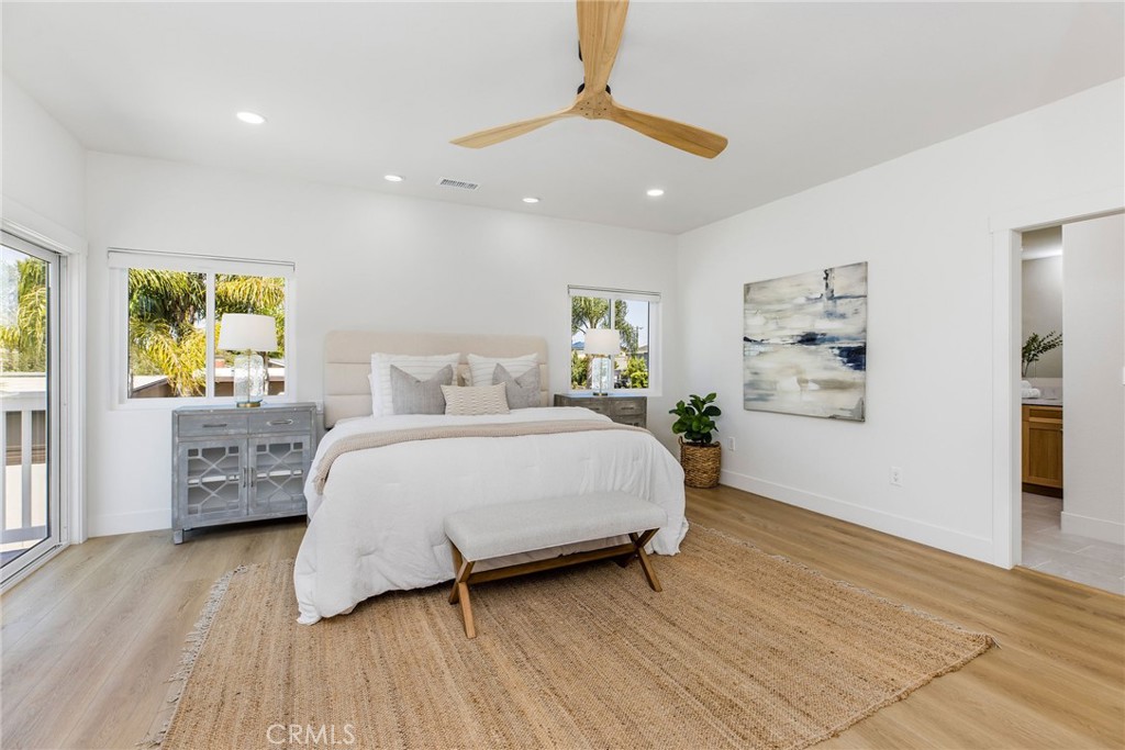 245 Surf Place Seal Beach, CA 90740 - Photo 45 of 65 a spacious bedroom with a bed and a wooden floor