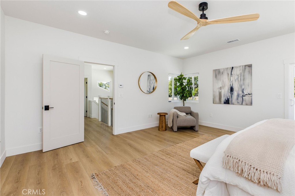 245 Surf Place Seal Beach, CA 90740 - Photo 46 of 65 a bedroom with a bed and a chandelier