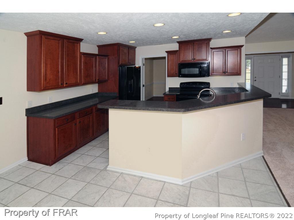 2886 Wade-Stedman Road Stedman, NC 28391 - Photo 5 of 26 a kitchen with stainless steel appliances a refrigerator sink a microwave and cabinets