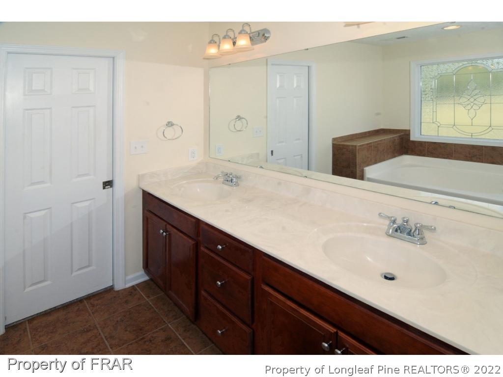 2886 Wade-Stedman Road Stedman, NC 28391 - Photo 10 of 26 a bathroom with a sink vanity and mirror