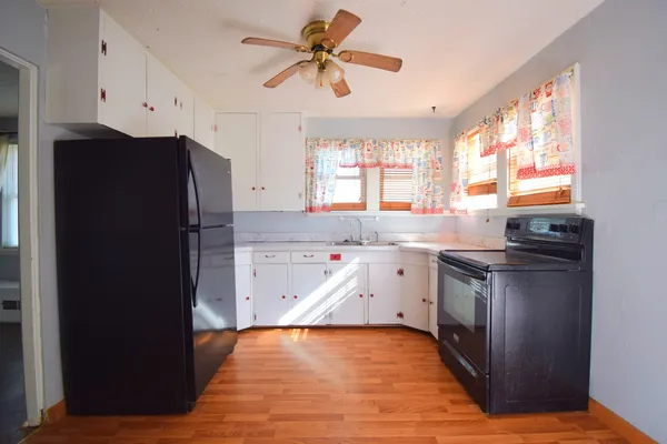 a kitchen with granite countertop a refrigerator and a sink