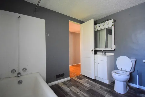a bathroom with a sink a toilet a window and shower