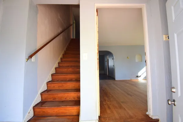 a view of a hallway with wooden floor and entryway