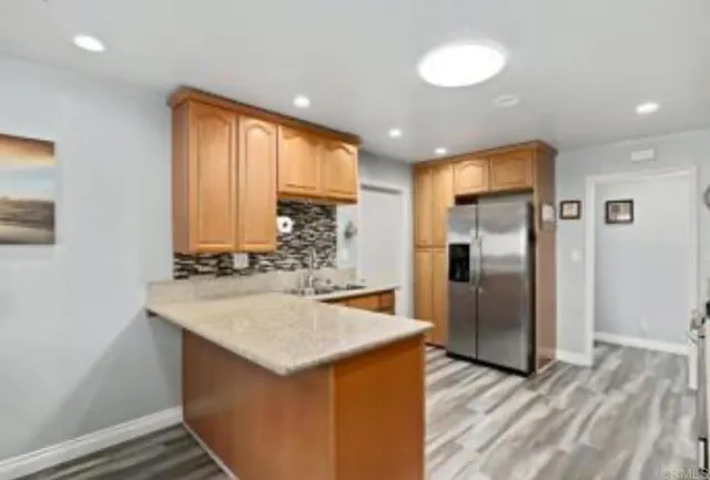 a kitchen with stainless steel appliances granite countertop a refrigerator and a sink