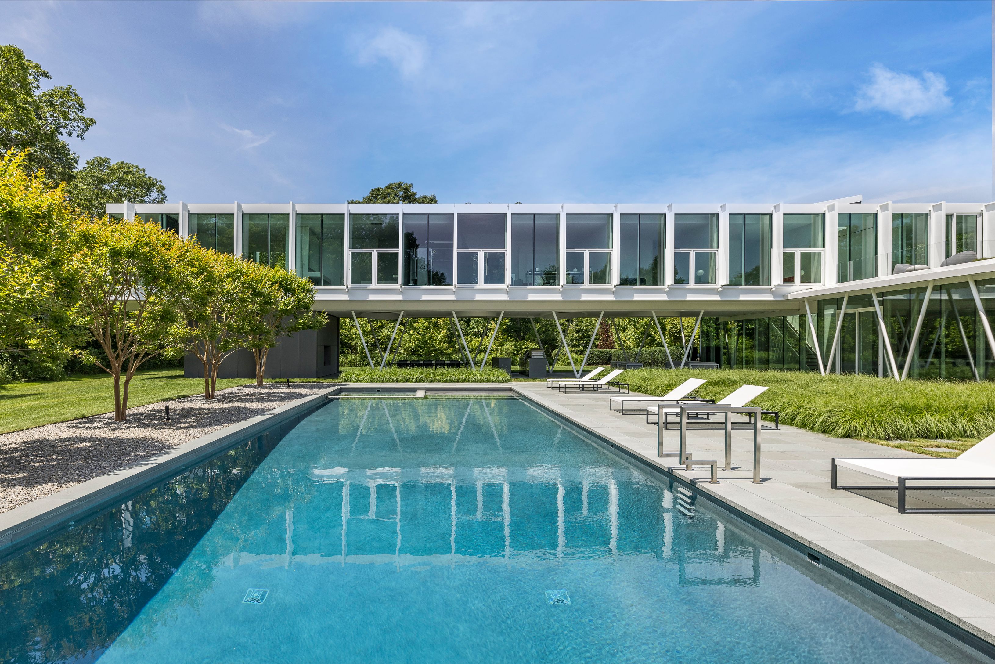 13 Terrys Trail East Hampton, NY 11937 - Photo 12 of 51 a front view of a house with a yard table and chairs