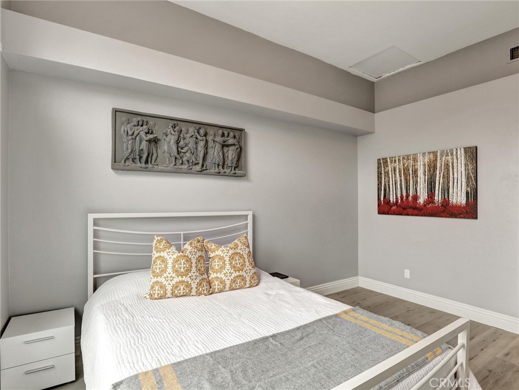 25081 Leucadia Street, Unit F Laguna Niguel, CA 92677 - Photo 15 of 30 a bedroom with a bed and a painting on the wall